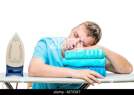 a tired man stroked the towels and fell asleep on the ironing board, his head lying on the towel Stock Photo