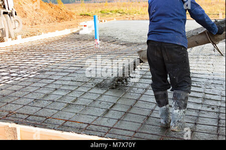 Closeup shot of concrete casting on reinforcing metal bars of floor in industrial construction site Stock Photo