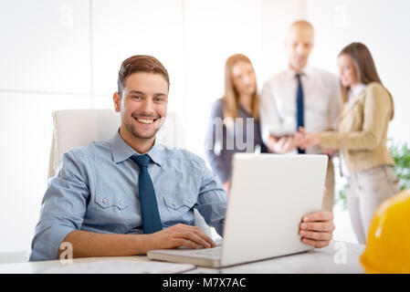 Young arabian male constructor using laptop in the office. Looking at camera. Stock Photo
