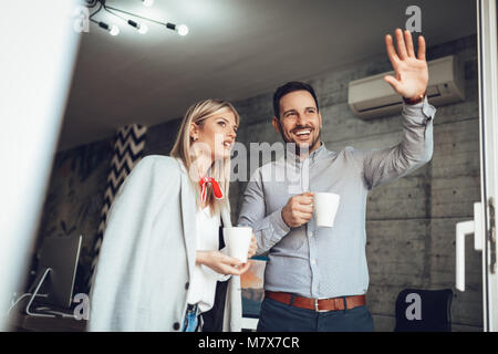 Business colleagues busy discussion and having coffee break at the office in front of balcony. Stock Photo