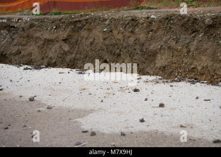 Side of the broken asphalt road collapsed and fallen, since the ground collapsing. Stock Photo