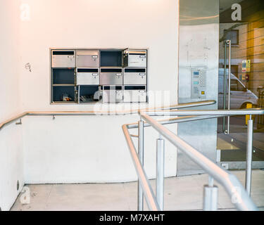 Mailboxes on the wall of an apartment building, vandalized letterboxes at entrance to apartments Stock Photo