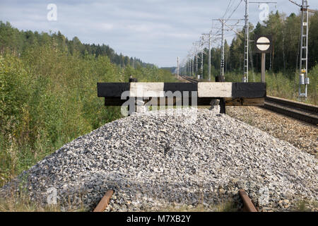 wooden buffer stop with red stop sign ending rail tracks concept for limit, limitation restriction boundary, prohibited, end , border Stock Photo