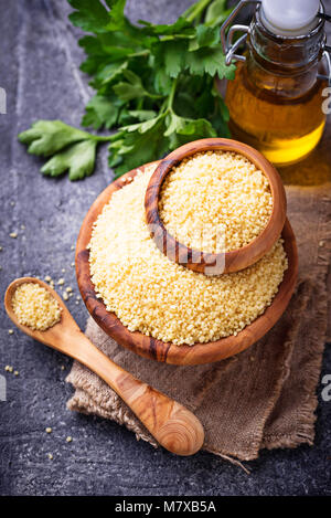 Couscous grain in wooden bowl  Stock Photo