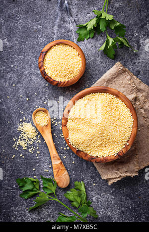 Couscous grain in wooden bowl  Stock Photo
