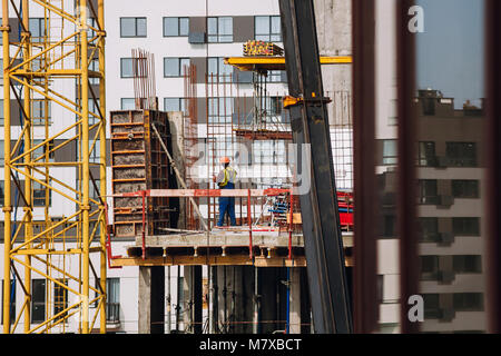 Workers engineers working at construction site and cranes on background of new building skyscrapers. Industrial landscape with building steel and conc Stock Photo