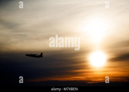 Airplane in the air at sunset  background with space for text. Silhouette of a big passenger or cargo aircraft in sun light. transportation concept. p Stock Photo
