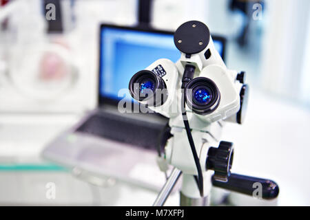 Microscope eyepieces and laptop on background Stock Photo