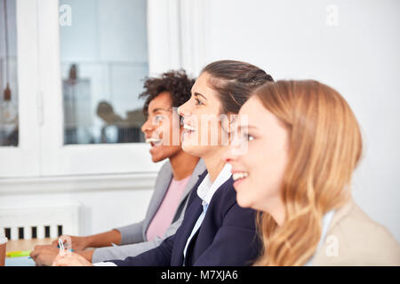 Three young business women are having fun in a seminar or start-up workshop Stock Photo