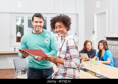 Successful multicultural start-up founder in coworking office with team Stock Photo
