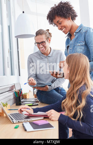 Young creative internet start-up team is working together on laptop computer Stock Photo
