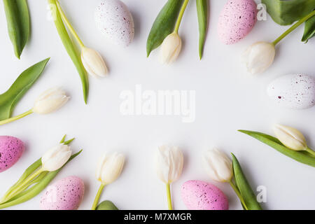 White flowers and speckled eggs on a white background. Studio shot. Easter and spring flat lay. Copy space. Stock Photo