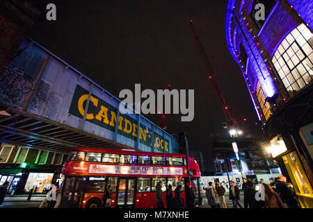 Blurred moving London red bus under Camden Lock bridge at night. Stock Photo