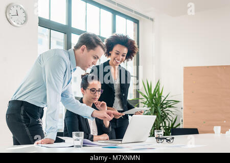 Three members of a young professional team working together Stock Photo