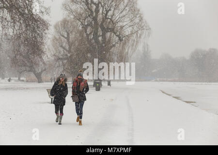 LONDON, UK: Two young women walking in white Regent's Park while it is snowing Stock Photo