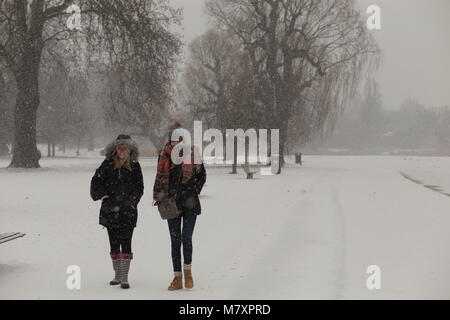 LONDON, UK: Two young women walking in white Regent's Park while it is snowing Stock Photo