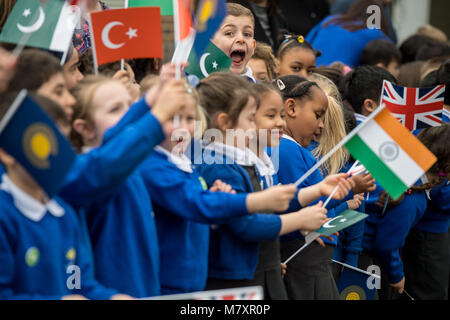 Children wave flags as the Duchess of Cornwall arrives to attend a Commonwealth Big Lunch with primary school pupils, at Barn Croft Primary School, London. Stock Photo