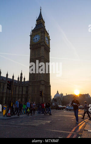 LONDON, UK: Tourists crossing the road in front of Big Ben during sunset Stock Photo