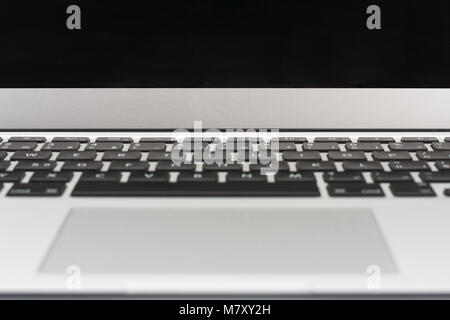 Part of open modern, new laptop close up, front view, blank black desktop on monitor. Stock Photo