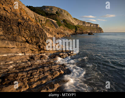 Waves breaking at the foot of the Great Orme, Llandudno, North Wales coast at sunrise Stock Photo