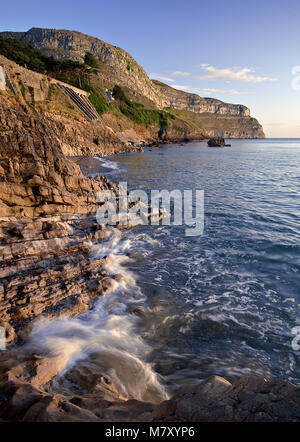 Waves breaking at the foot of the Great Orme, Llandudno, North Wales coast at sunrise Stock Photo