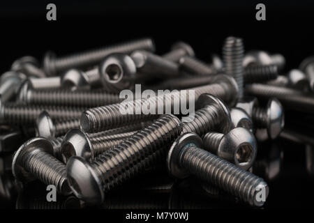 metal fasteners screws and nuts on black background. screw isolated on the black backgrounds. Nuts with bolts closeup Stock Photo