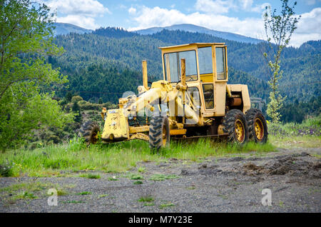 Old grader on mountainous road construction Stock Photo