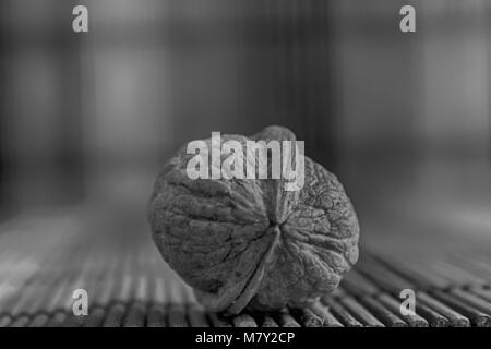 Monochrome Walnut lie on a wooden bamboo table, background for web site or mobile devices. Stock Photo