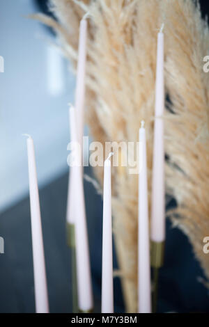 Long pink handmade candles in a candlestick Stock Photo