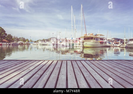 Wooden decking or walkway and view of yacht standing at the marina in Phuket, Thailand Stock Photo