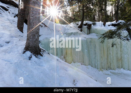 Eben Ice Caves in Michigan's Upper Peninsula spill over a rock ledge, like a waterfall, creating patterned ice curtains, near Eben Junction Michigan. Stock Photo