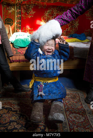 Hatgal, Mongolia, 2nd March 2018: mongolian boy dressed in traditional deel in his home ger (yurt) Stock Photo