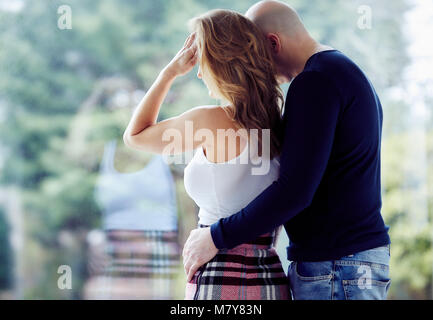 Couple stood looking out of window Stock Photo