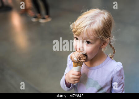 child eating ice cream cone in marketplace Stock Photo