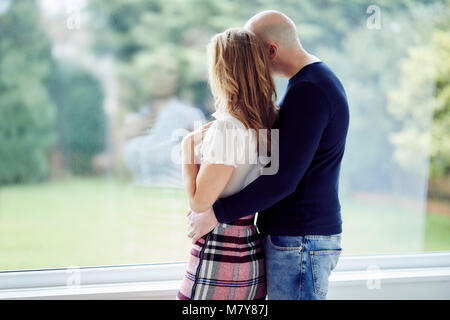 Couple stood looking out of window Stock Photo: 177005481 - Alamy