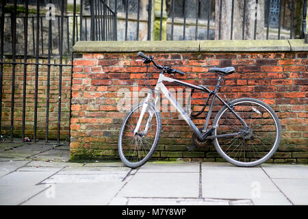 Mountain bikes padlocked against a brick wall as part of the cycle to work scheme or the Transport for London bicycle scheme in the UK Stock Photo