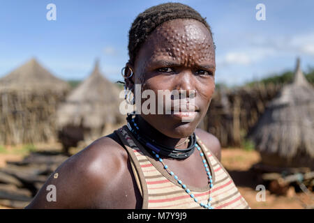 Portrait of a karamajong woman with scars on her face forming a pattern as a beauty and identity sign. I took her portrait inside one of the fortified Stock Photo