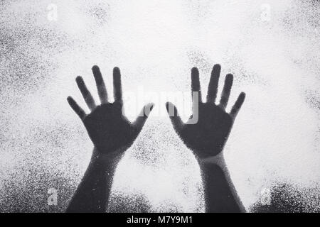 Top view hand prints in flour or white powder on black table background Stock Photo