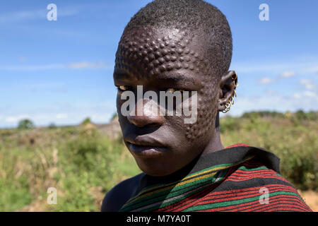 Portrait of a karamajong man with scars on his face forming a pattern as a beauty and identity sign. Most of the Karamajong are very proud to show the Stock Photo