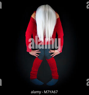 A mature woman, posing in an abstract artistic style, bent over towards camera with long white hair hanging down, wearing red sweater and leg warmers, Stock Photo