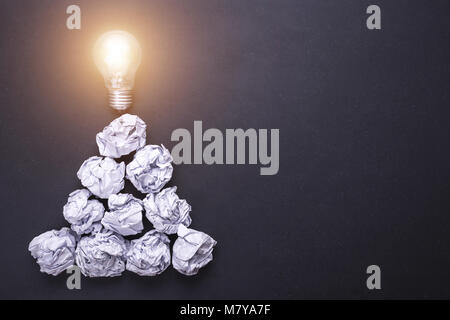 Top view crumpled white paper and light bulbs on black stone board. Create idea concept Stock Photo