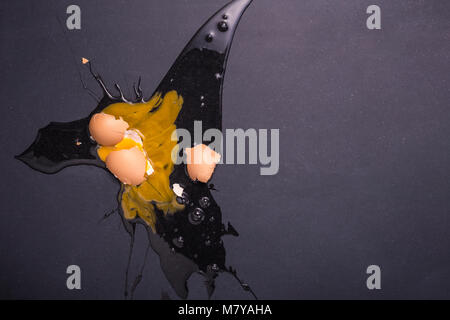 Top view broken eggs on the black stone ground. Free space for text and design Stock Photo
