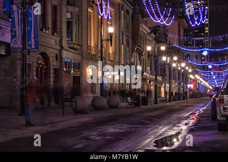 Calgary Night Life. A long exposure created blurred lights of vehicles and blurred people moving down Stephen Avenue in Calgary, Alberta, Canada. Stock Photo
