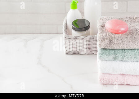 Spa relax and bath concept, sea salt, soap, with cosmetics and towels in bathroom white background, copy space top view Stock Photo