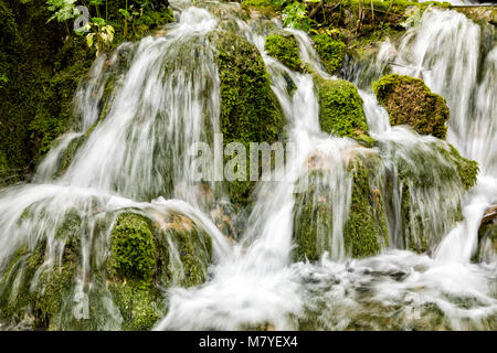 Small waterfall flows over moss-covered stones in Plitvice Lakes National Park in summer in Croatia Stock Photo