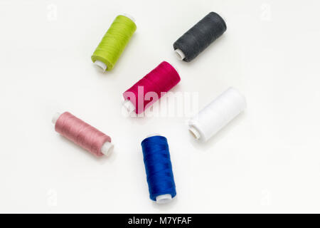 Colored thread coils on white background, sewing, place for text Stock Photo