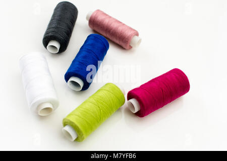 Colored thread coils on white background, sewing, place for text Stock Photo