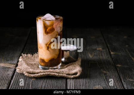 Iced coffee in a tall glass with ice on top. Stock Photo