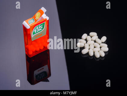 Tic tacs isolated on dark background. Tic tacs are manufactured by Italian confectioner Ferrero and were first produced in 1968. Stock Photo