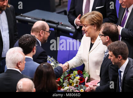 Berlin, Germany. 14th Mar, 2018. Angela Merkel is congratulated by Martin Schulz, former leader of Social Democratic Party (SPD), after being re-elected as chancellor in Berlin, Germany, March 14, 2018. Angela Merkel was re-elected as German chancellor on Wednesday by the parliament, kicking off her fourth term to lead Europe's largest economy. Credit: Shan Yuqi/Xinhua/Alamy Live News Stock Photo